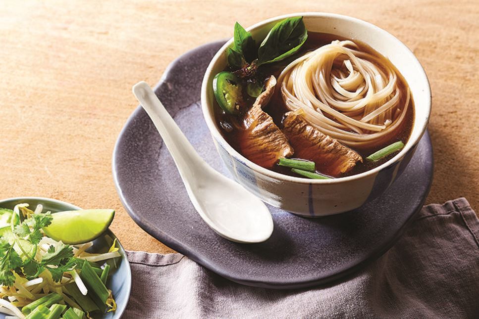 Bowl of beef pho with soup spoon